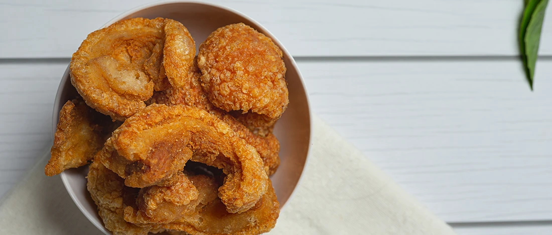 A close up image of pork rinds in a bowl