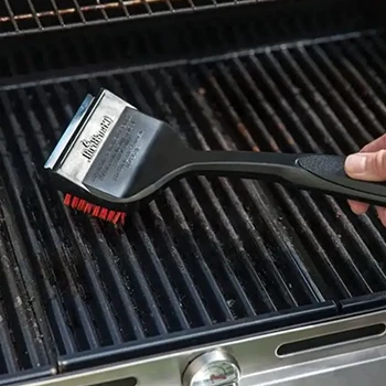 A person brushing and cleaning a smoker grill