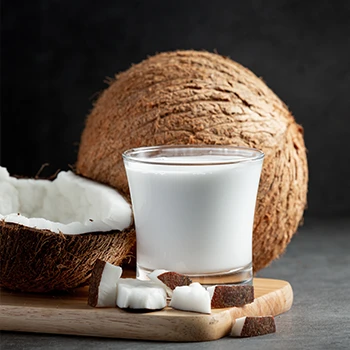 An image of coconut and a glass of coconut milk