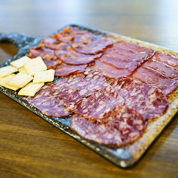 A photo of different cured meats on a cutting board