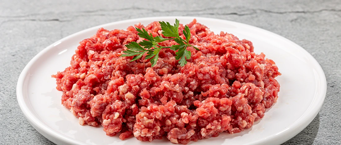 An image of ground beef on a white plate