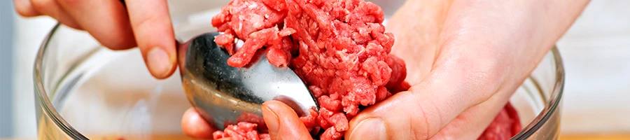 A woman preparing ground beef by hand