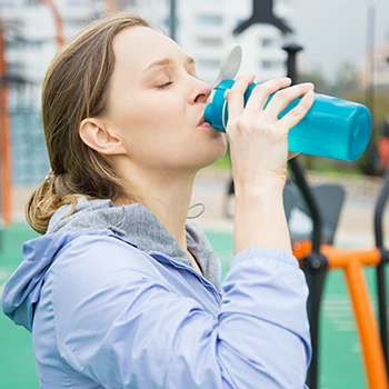 A woman drinking water from a bottle