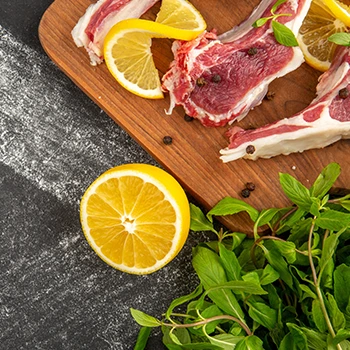 An image of raw meat with sliced lemons