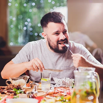 A man eating meat on a dining table