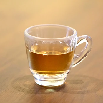 A close up image of a cup of tea on a desk