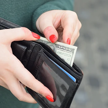 A woman pulling out money from her wallet