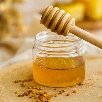 A close up image of a honey on top of a wooden board