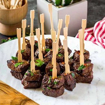 An image of steak bites with wooden stick on top