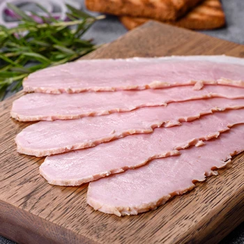 An image of sliced ham on a wooden board