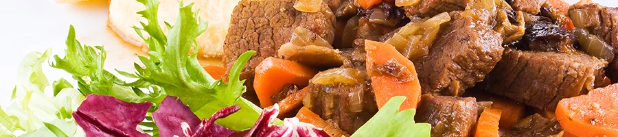 A close up image of beef pot roast and vegetables