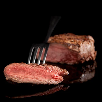 A close up image of a sliced meat with a fork