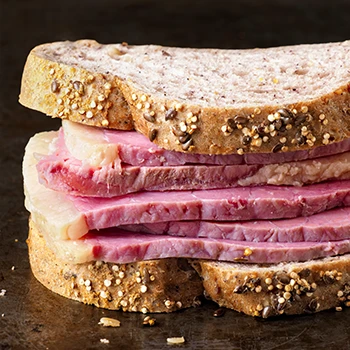 An image of corned beef sandwich on a grill