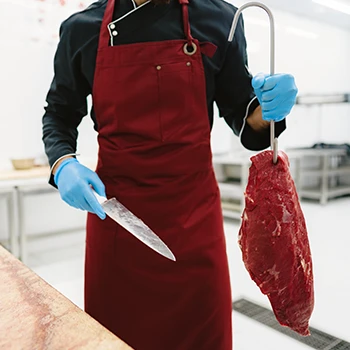 A butcher holding a knife and a meat