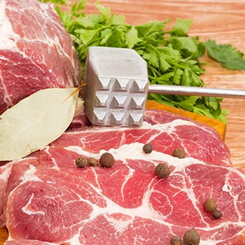 A close up image of meat and meat tenderizer