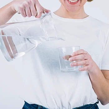 A woman pouring a glass of water