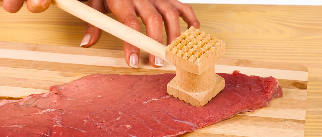 An image of a person tenderizing meat