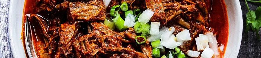 A top view of birria meat in a white bowl