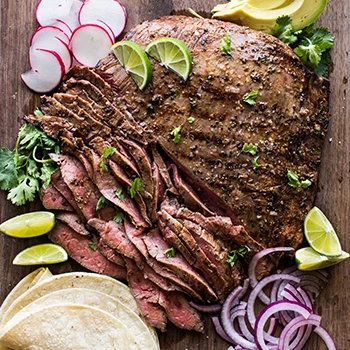 A top view image of carne asada on a wooden board