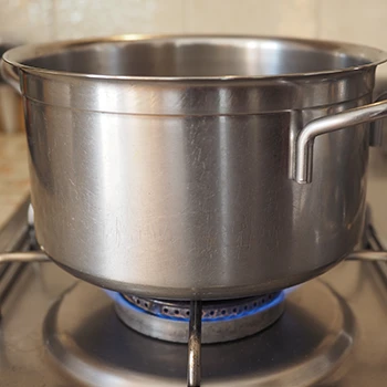 An image of a boiling sauce pot on a burner stove