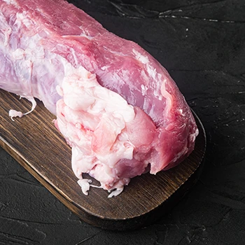 A raw pork loin on a wooden board