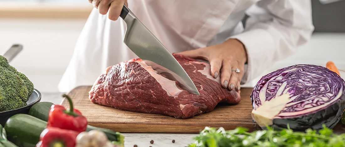 An image of a woman cutting cow meat
