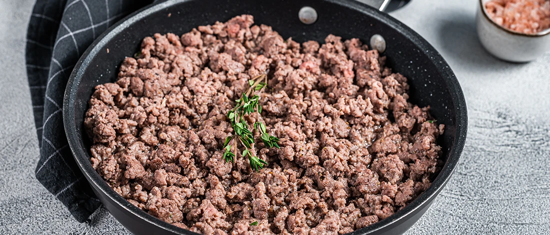 An image of brown ground beef on a pan