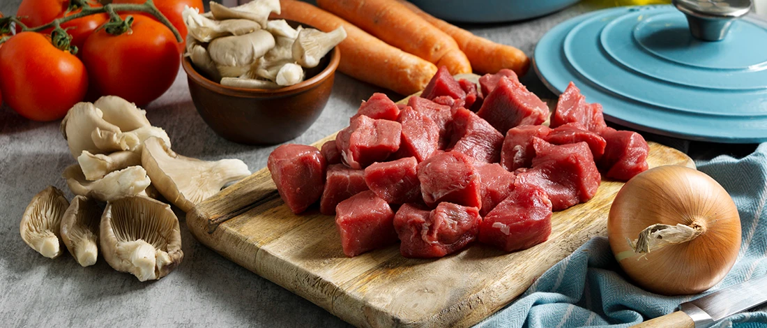 An image of stew meat on a wooden board