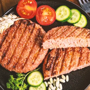 A top view image of plant-based meat with different vegetables on a plate