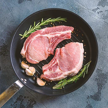 A top view image of pork shoulder chops on a pan