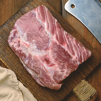 A top view image of raw pork tenderloin on a chopping board