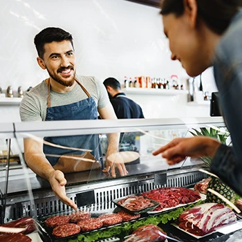 A woman buying meat from a butcher