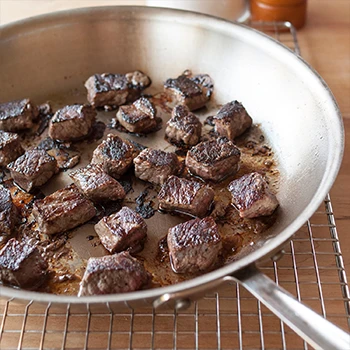 An image of seared beef on a pan