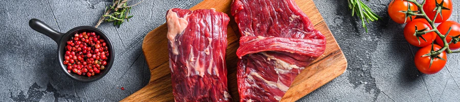 An image of raw flank steak on a cutting board