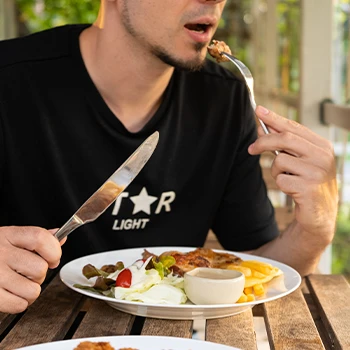 A person eating meat that can cause meat sweats