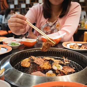 An image of a woman enjoying Japanese BBQ