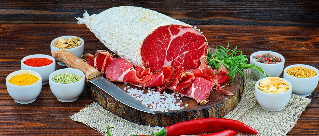 An image of capicola meat on a wooden board