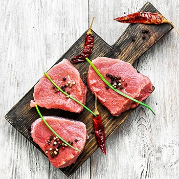 A top view image of raw veal meat on a wooden board