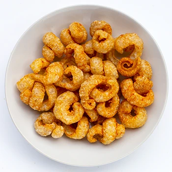 A top view image of crispy pork rinds on a white bowl