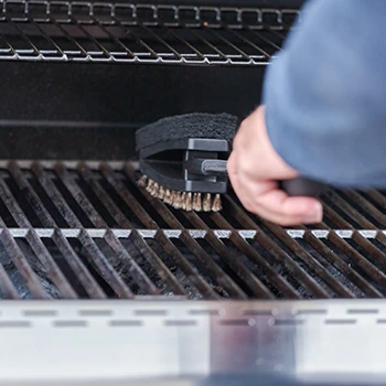 An image of a person cleaning a pellet grill