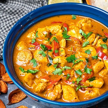 An image of keto chicken curry in a blue bowl