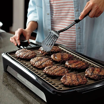 An image of a person cooking using a grill with removable plate