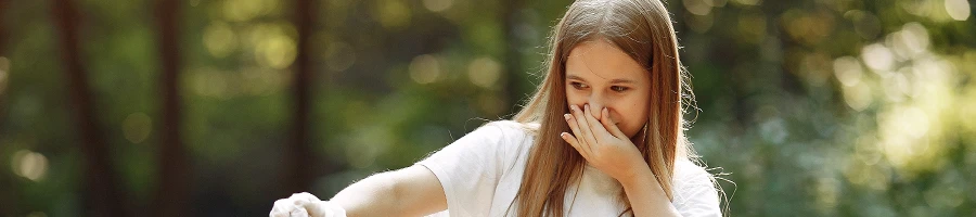 An image of a woman holding her nose because of a bad smell