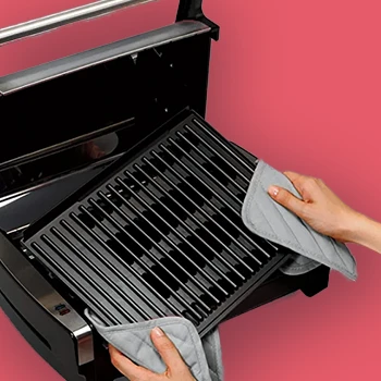 An image of a person removing a grill plate