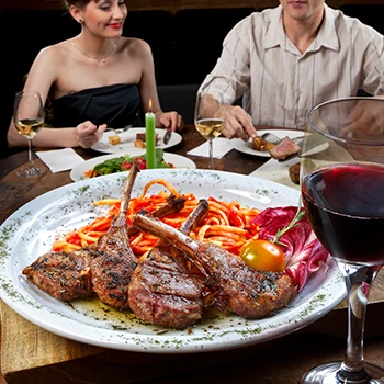 An image of a couple eating cooked lamb dish