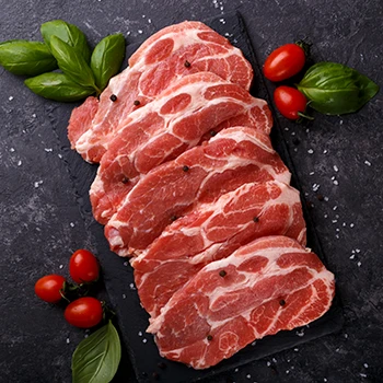 A top view image of pork slices on top of a black slate