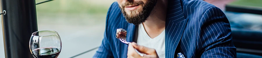 An image of a man who is about to eat a meat on a fork