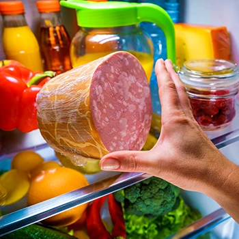 An image of a hand storing deli meat inside a refrigerator