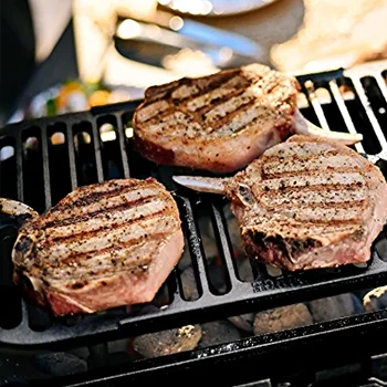 A close up image of hibachi grill with cooking meats on top