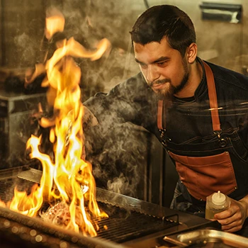 A chef looking closely at the steak while being cooked